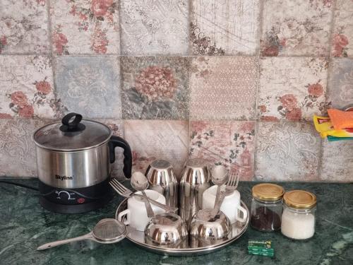 TiNY HOMESTAY for International Guest only في شيملا: كاونتر مطبخ مع وعاء الشاي والأواني