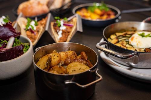 a table topped with bowls of food and plates of food at Novotel Bordeaux Centre Ville in Bordeaux