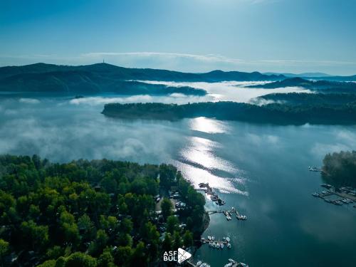 an aerial view of a lake with clouds and trees at Przystań Caryńska w Polańczyku in Polańczyk