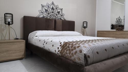 1 dormitorio con 1 cama grande y cabecero de madera en L'Angolo di Sarah, en Santo Stefano di Camastra