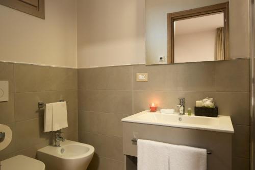 a bathroom with a sink and a toilet and a mirror at Luci di Assisi B&B Wellness in Assisi