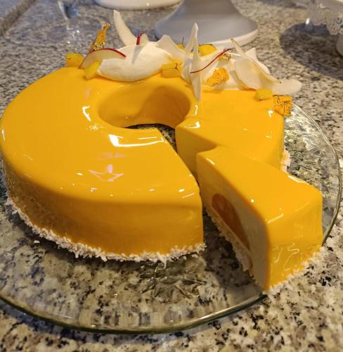 a yellow cake on a glass plate on a table at Hotel Forma in Piła