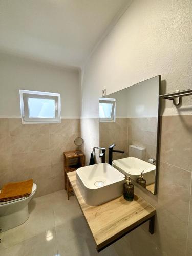 a bathroom with a tub and a sink and a toilet at Pine & Apple Sintra Beach House in Colares