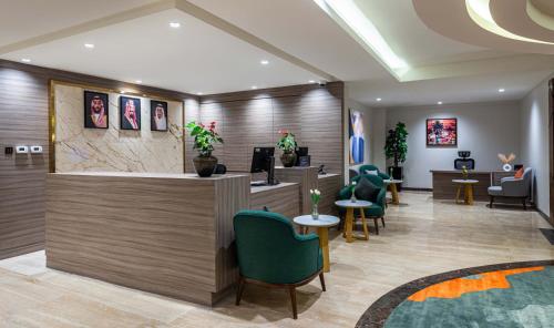 a lobby with a waiting area with green chairs at Best Western Plus Tabuk City Center in Tabuk