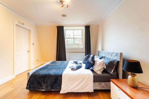 Schlafzimmer mit einem Bett und einem Fenster in der Unterkunft PLACIFY Riverside Penthouse in Chelsea Near King's Road in London