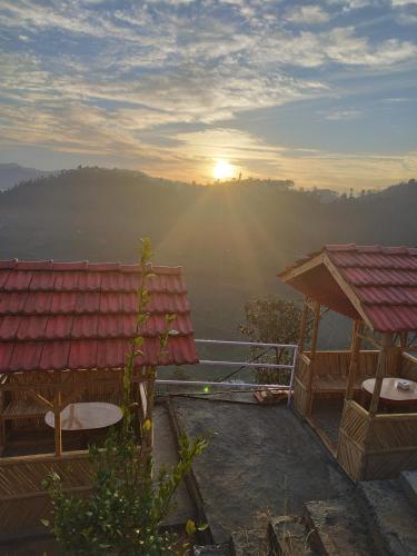 uma vista para o nascer do sol a partir de uma casa com um telhado em Balthali himalaya view point restro em Panaoti