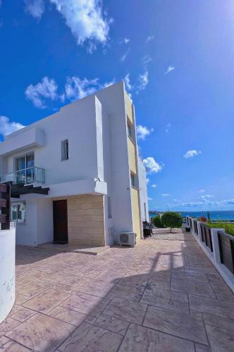 een groot wit gebouw met een blauwe lucht bij 3 Bedroom Coral Bay Panorama Seaview Villa Pool in Coral Bay