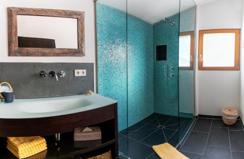 uma casa de banho com um lavatório e um chuveiro em Naturchalets 7 Sentidos em Bischofsmais