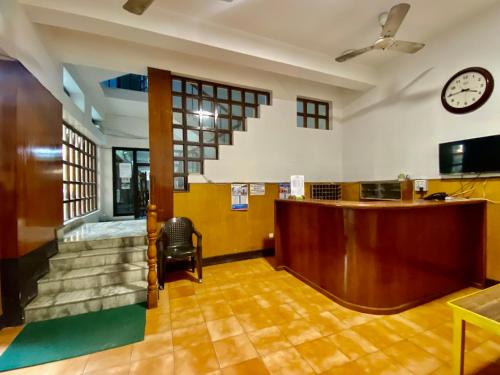 a waiting room with a desk and a clock on the wall at Hotel Sova's Inn in Birātnagar