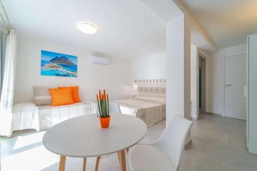 Brorent Affittacamere moro dream في أولبيا: غرفة معيشة بيضاء مع طاولة وأريكة