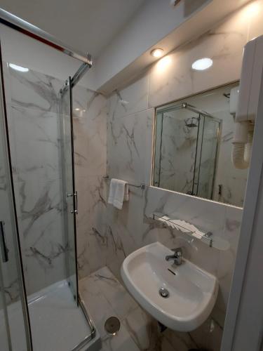 a white bathroom with a sink and a shower at Hotel Positano in Rome