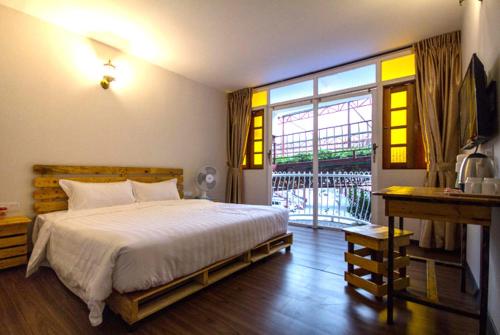 um quarto com uma cama e uma grande janela em Kea Garden Guest House em Brinchang