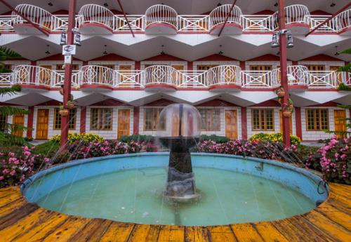 une fontaine dans une piscine en face d'un bâtiment dans l'établissement Kea Garden Guest House, à Brinchang