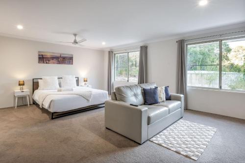 - une chambre avec un lit, un canapé et une chaise dans l'établissement Villa 16 @ Rivendell Winery Estate - Yallingup, à Yallingup Siding