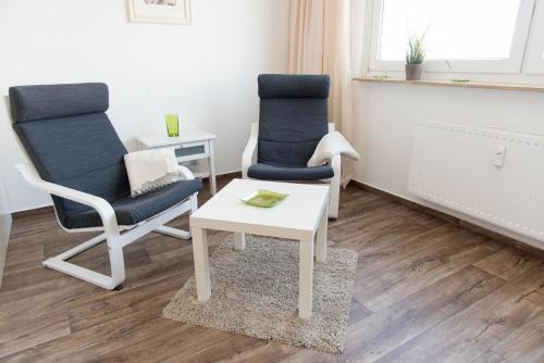 twee stoelen en een tafel in de woonkamer bij Ferienwohnung Kleine Moewe in Schilksee