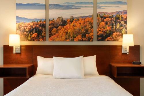 a bedroom with a bed with three paintings on the wall at Days Inn by Wyndham Dillon in Dillon