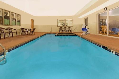 a large swimming pool with chairs and a table at Days Inn & Suites by Wyndham Castle Rock in Castle Rock