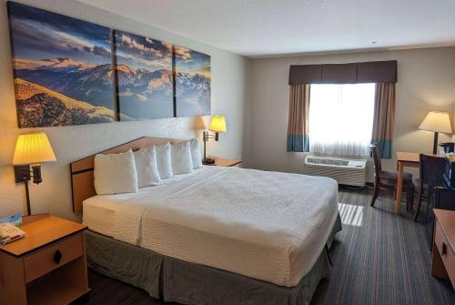 Habitación de hotel con cama grande y ventana en Days Inn & Suites by Wyndham Castle Rock, en Castle Rock