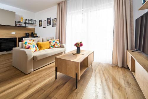 a living room with a couch and a table at Symphony City Square Aparthotel in Wrocław