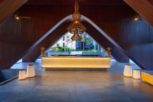 a lobby with a large window and a chandelier at Wyndham Tamansari Jivva Resort Bali in Keramas
