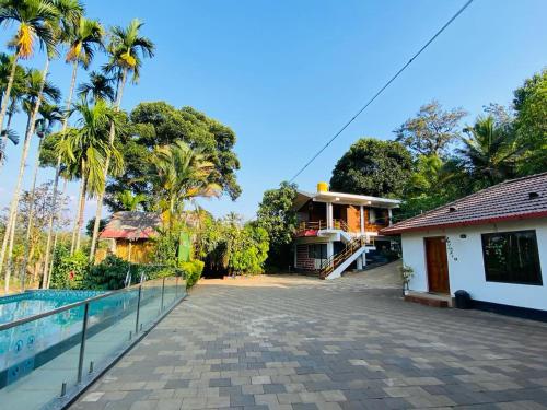 Pool Villa of COORG في ماديكيري: منزل به ممشى بجوار مبنى