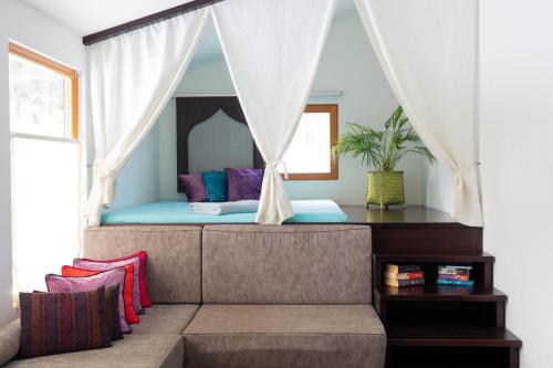 Bett in einem Zimmer mit Sofa und Fenster in der Unterkunft Naturchalets 7 Sentidos in Bischofsmais
