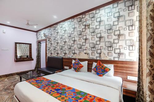 a hotel room with a bed and a wall at FabHotel Deepak Palace in Varanasi