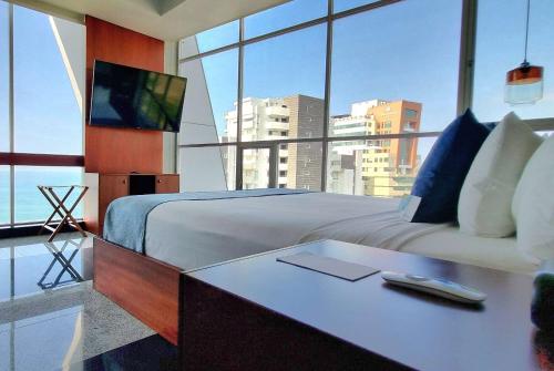 a bedroom with a bed and a desk with a television at Wyndham Manta Sail Plaza Hotel and Convention Center in Manta