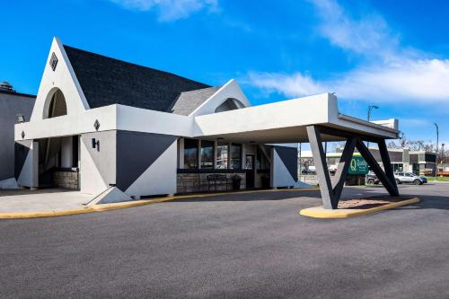 a white building with a black roof on a street at Quality Inn & Suites Council Bluffs - Omaha East in Council Bluffs