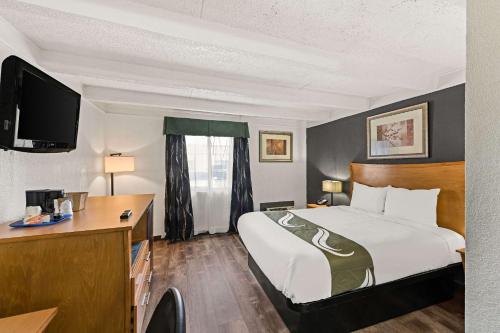 a hotel room with a bed and a desk at Quality Inn & Suites near I-480 and I-29 in Council Bluffs