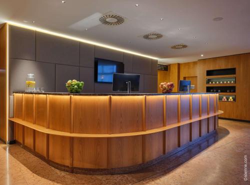 a hotel lobby with a reception desk and a television at Dorint City-Hotel Salzburg in Salzburg