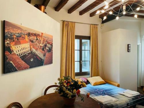 a bedroom with a bed and a table with flowers on it at Bella Ciao Old Town in Bergamo