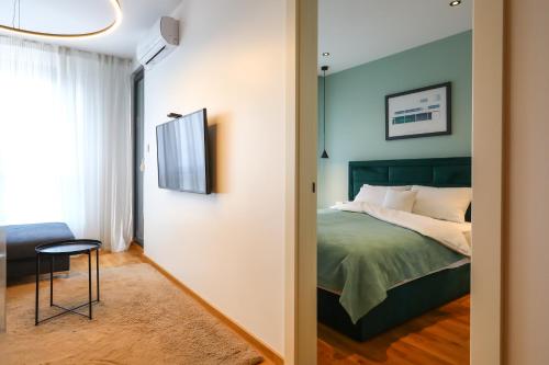 a bedroom with a bed and a table and a chair at Apartment Sanja in Novi Sad