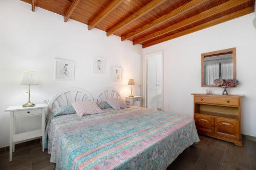 1 dormitorio blanco con 1 cama y 2 mesitas de noche en Apartamentos Toledo, en Caleta de Sebo