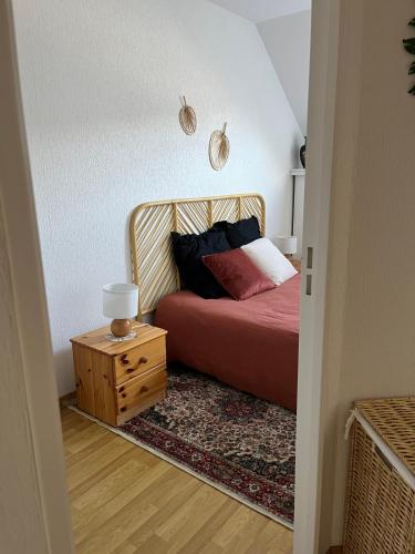 une chambre avec un lit et une table de chevet en bois dans l'établissement Maison 2 chambres chez virginie, à Quiberon