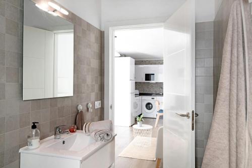 Baño blanco con lavabo y espejo en Apartamentos Toledo, en Caleta de Sebo