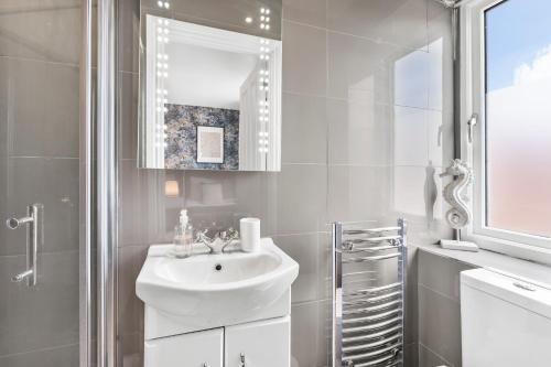 biała łazienka z umywalką i prysznicem w obiekcie The Chaucer - Stylish City Centre Gem - Sleeps 7 w mieście Kent