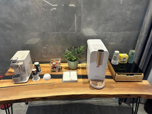 a wooden table with two coffee machines on it at KAME HOTEL BELGRADE,贝尔格莱德凯美酒店 in Ledine