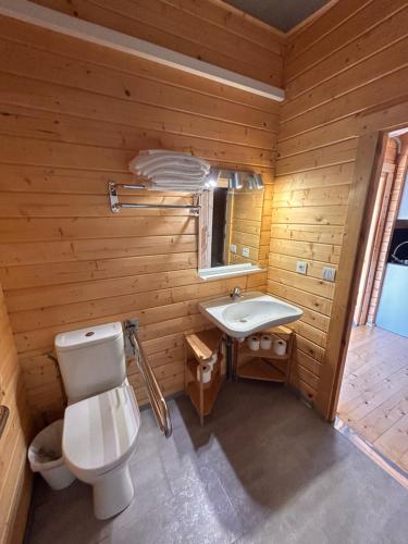 baño de madera con aseo y lavamanos en Camping & Bungalows Leagi en Mendexa