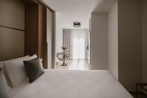 a bedroom with a white bed and a table at The Sliema Suites in Sliema