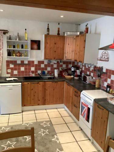 a kitchen with wooden cabinets and a white stove top oven at Sundown in Paillé