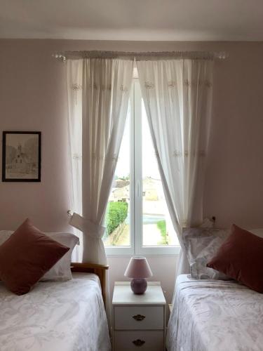 a bedroom with two beds and a window at Sundown in Paillé