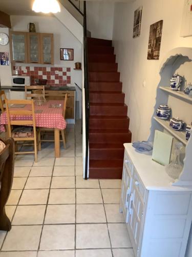 a kitchen and dining room with a staircase and a table at Sundown in Paillé