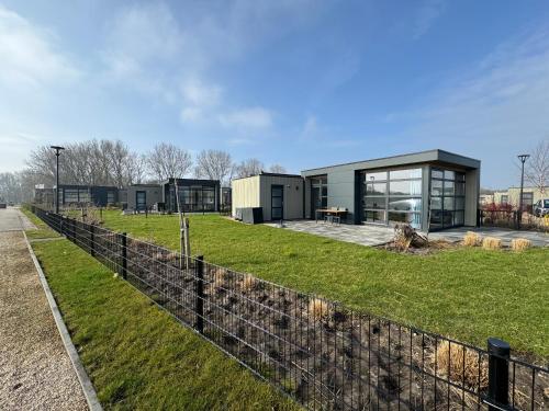 a building with a fence in front of it at Enkhuizer Strand Chalet Strandpanorama Zweite Reihe mit Zaun Hausnr 203 in Enkhuizen