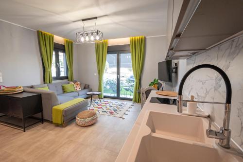 Il dispose d'une cuisine et d'un salon avec un canapé et un évier. dans l'établissement Sagman Suite by RentalsPro Services - Nea Moudania Halkidiki, à Nea Moudania