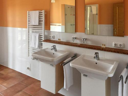 La salle de bains est pourvue de 2 lavabos et de 2 miroirs. dans l'établissement Chalet-Chip-In Bad Griesbach - Uttlau, à Haarbach