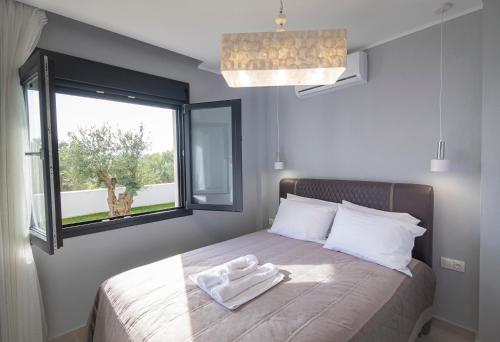 - un lit avec une serviette et une fenêtre dans l'établissement Sagman Suite by RentalsPro Services - Nea Moudania Halkidiki, à Nea Moudania