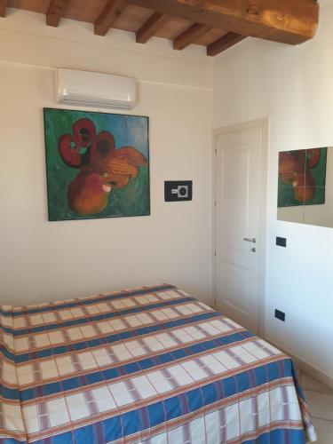 1 dormitorio con 1 cama y una pintura en la pared en Condominio Vacanze Centro Storico en Massa