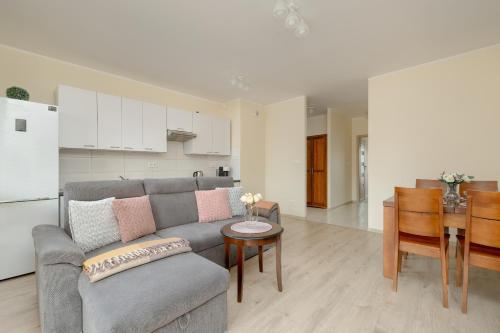 a living room with a couch and a table and a kitchen at Wilczak Spacious Apartment with FREE GARAGE Poznań by Noclegi Renters in Poznań