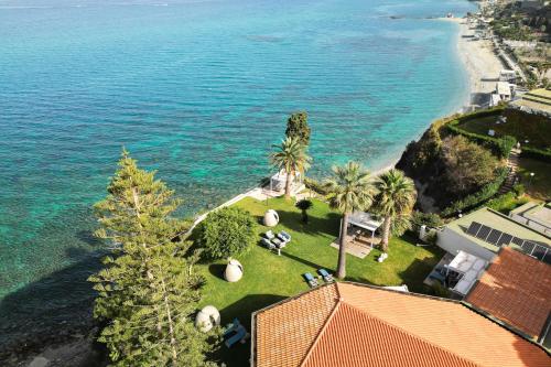 z góry widok na plażę z palmami i dom w obiekcie Labranda Rocca Nettuno Tropea w Tropei